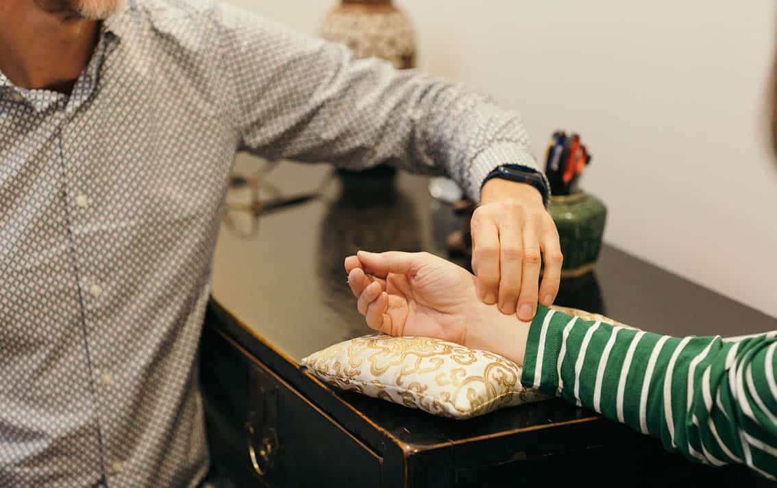 Therapist checking the pulse on a patient's wrist.